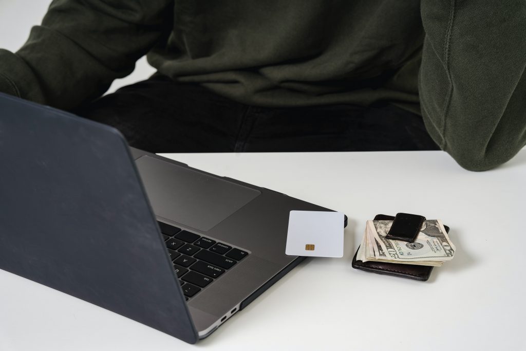 Un personal computer accanto a una carta bianca, venti dollari e un portafoglio.