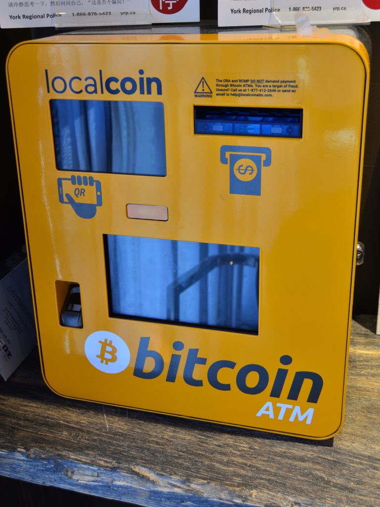 ATM Bitcoin Oranye dengan logo Bitcoin