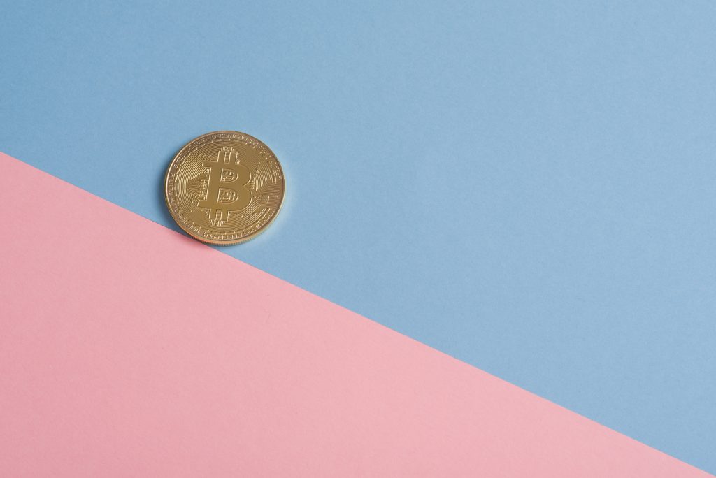 淡蓝色和粉红色背景的比特币硬币，可帮助用户了解什么是聪